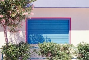Blue shuttered window with pink flowering tree